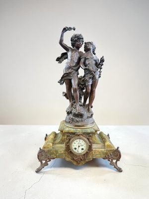 une statue représentant un garçon et une fille sur une horloge