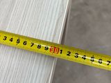 measuring the length of a piece of wood with a tape measure