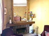 a living room with two purple chairs and a mirror