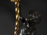 a bronze statue of a boy holding a flower in his hand