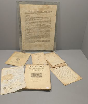 un vieux livre posé sur une table, à côté d'une pile de papiers