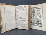 un vieux livre ouvert sur une page où figurait le dessin d'un homme assis sur une chaise