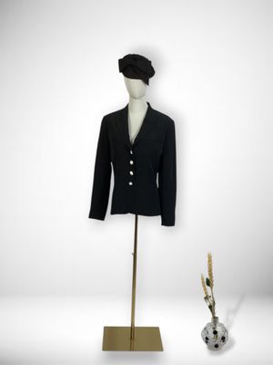 mannequin with black jacket and black hat on a gold stand