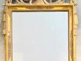 a mirror on the wall with a gold frame
