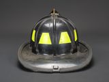 a fireman ' s helmet with yellow eyes on it