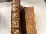 deux vieux livres posés sur une table à côté d'une paire de chaussures