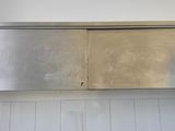 a stainless steel cabinet above a sink in a bathroom