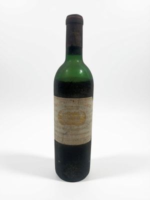 une vieille bouteille de vin posée sur une surface blanche