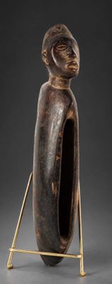 une photo d'une sculpture en bois représentant une personne dont la tête repose sur un socle