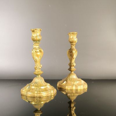pair of antique brass candlesticks on a black table