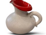 a white pitcher with a red lid on a white surface