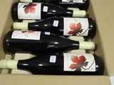 six bottles of red wine in a cardboard box on a table