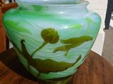 a green vase sitting on top of a wooden table
