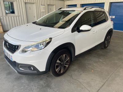 une voiture blanche garée dans un garage dont la porte est bleue