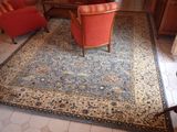 un grand tapis avec une chaise rouge au milieu