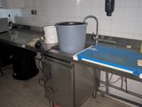une cuisine équipée d'un évier et d'une poubelle posée sur le plan de travail