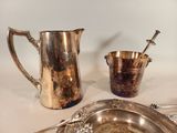 a silver plate and a silver pitcher on a table