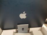 an apple laptop computer sitting on top of a box on top of a table