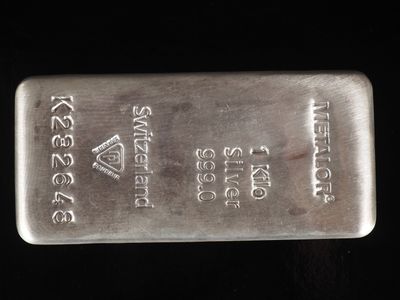 un gros plan d'un lingot d'argent posé sur une surface noire