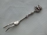 a silver spoon with a bird on it on a table