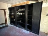 a black bookcase in the middle of a room