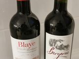 two bottles of wine sitting next to each other on a counter