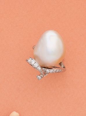 une image représentant une bague en perle blanche et diamants sur fond rose