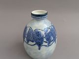 un vase bleu et blanc posé sur une surface grise
