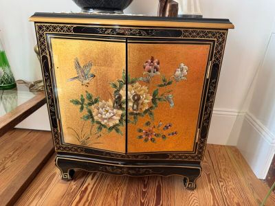 a small cabinet with flowers and birds painted on it