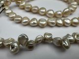 a white pearl necklace on a table with a silver clasp
