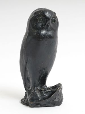 une image représentant une statue de chouette perchée sur une souche d'arbre
