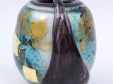 a close up of a vase on a white surface