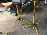 a man that is standing in a garage with a wheelbarrow
