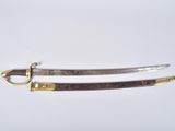 two swords with gold and silver on them on a white surface