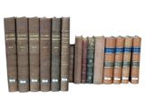 several old books are stacked on top of each other on a white surface