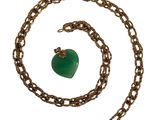 chaîne en plaqué or avec un pendentif en forme de cœur vert sur fond blanc