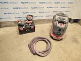 two vacuums and a hose are sitting on the floor in front of a wall