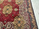 a red and gold rug on a white floor