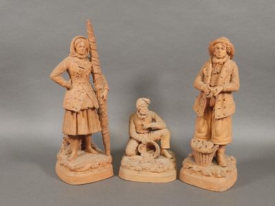 trois figurines sculptées représentant des hommes et des femmes en costume traditionnel