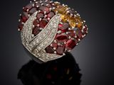 a close up of a red and yellow diamond ring on a black surface