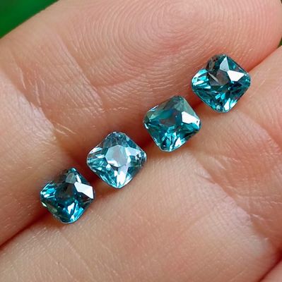 une personne tenant une paire de diamants bleus dans la main