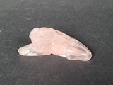 rose quartz animal figurine on a black surface