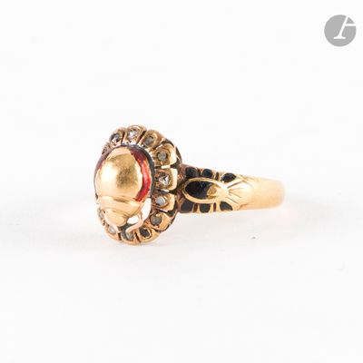 gros plan d'une bague en or avec une pierre rouge au centre