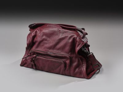 sac à main en cuir posé sur une surface blanche, sur fond noir