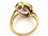 a close up of a gold ring with a purple stone