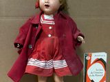 a doll that is sitting on the floor next to a cardboard box