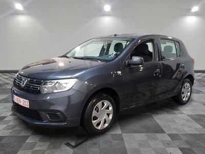 La Dacia grise est garée dans une pièce au sol carrelé en damier.
