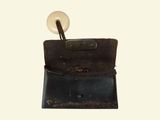 an old wallet with a button on it sitting on a table