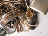 a pile of silver and gold jewelry on a white table