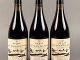 trois bouteilles de vin sont alignées sur une table